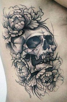 a man's stomach with a skull and flowers tattoo on his side ribcage