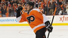 an ice hockey player is on the ice with his arms in the air and one hand up