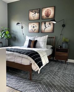 a bed room with a neatly made bed and pictures hanging on the wall above it