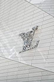 the louis vu logo is on top of a white brick wall in front of a building