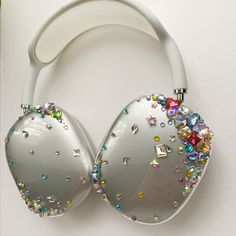 a pair of white headphones with colorful jewels on them