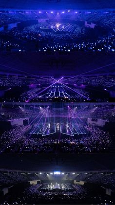 an aerial view of a stadium at night with bright lights on the stage and in the audience