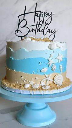 a blue and white birthday cake with shells on it