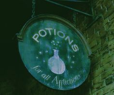 a sign hanging from the side of a brick building that says potions for all africtors