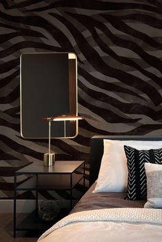 a zebra print wallpaper in a bedroom with a bed and night stand next to it