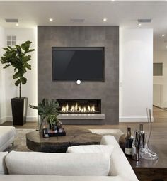 modern living room with fireplace and flat screen tv on the wall, white couches