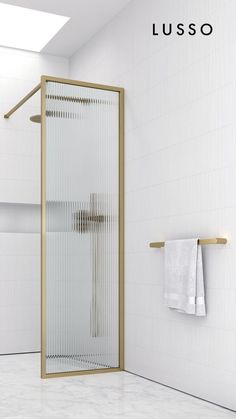 a white tiled bathroom with a shower and towel rack on the wall next to it