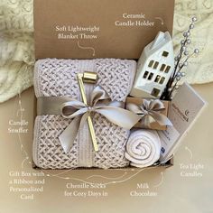 the contents of a gift box wrapped in white yarn and tied with silver ribbon,