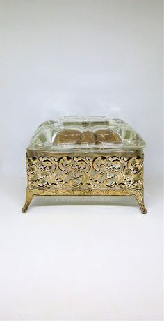 a gold and glass box with two pieces of food in it sitting on a white surface