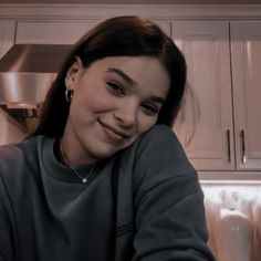 a woman sitting on top of a kitchen counter