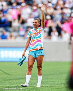 a female soccer player waves to the crowd