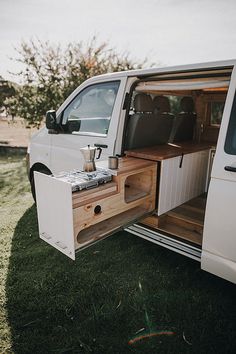 a white van with its doors open on the grass