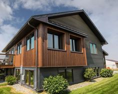 a house that is in the grass with windows on each side and an attached deck