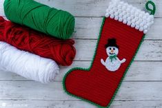 three christmas stockings with snowmen on them, one is red and the other is green