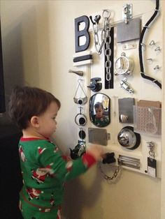 a little boy that is standing in front of a wall with many items on it