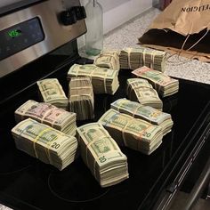 stacks of twenty dollar bills sitting on top of an oven