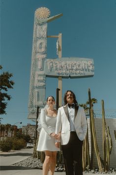 a man and woman standing in front of a sign