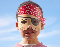 a young boy wearing a pirate mask with polka dots on it's face and nose