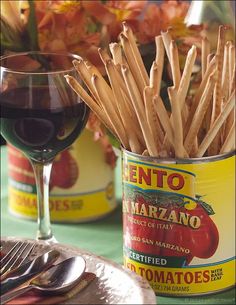 there is a glass of red wine and some sticks in the jar on the table