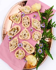 small pastries on a pink plate with flowers and greenery next to the top