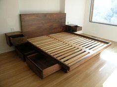 a wooden bed frame with drawers underneath it