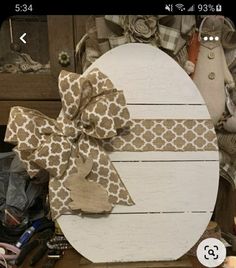 a wooden sign with a bow on it sitting on top of a table next to other items