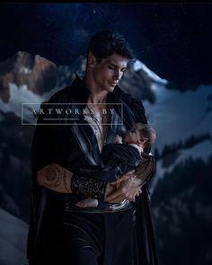 a man holding a baby in his arms while wearing a leather jacket and black pants