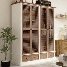 a bedroom with white walls and wooden shutters