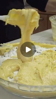 a person mixing batter in a bowl on top of a table