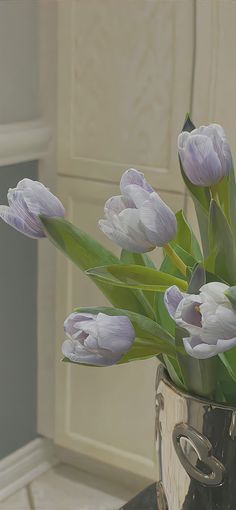 a vase filled with purple flowers on top of a table