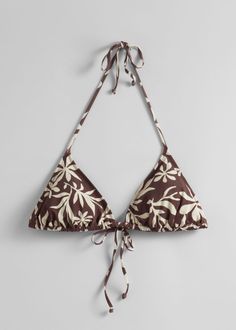 Triangle bikini halterneck top detailed with a bow at the front and the neck. Featuring removable padding. Chic Triangle Halter Top For Beach Season, Chic Triangle Halter Top For Sunbathing, Chic T-back Swimwear For Beach, Brown Halter Neck Top For Beach Season, Bra-friendly Brown Swimwear For Vacation, Brown Triangle Halter Top For Beachwear, Brown Triangle Halter Top For Vacation, Brown Triangle Halter Top, Brown Summer Halter Top For Vacation