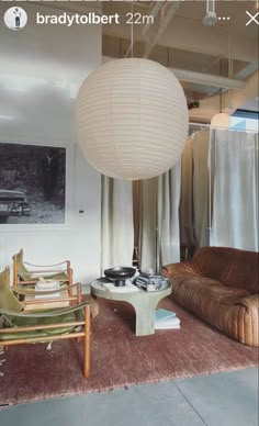 a living room filled with furniture and a large white ball hanging over it's head