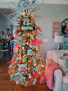 a decorated christmas tree in a living room with blue and red ornaments on the top