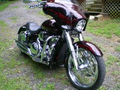 a black and red motorcycle parked in the grass