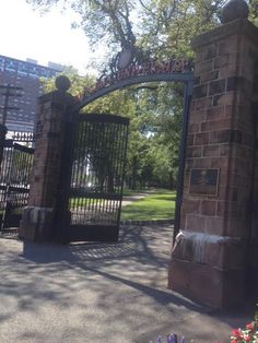 an iron gate is open to let people know what's in the park behind it