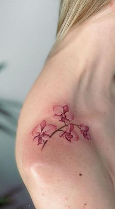 a woman's shoulder with pink flowers on it