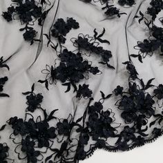 an image of black flowers on white sheer fabric with sequins and lace trim