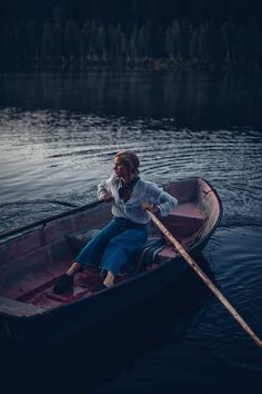 a woman sitting in a boat on the water