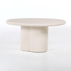 a white round table sitting on top of a white floor