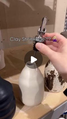 a person is holding an object in their hand while standing next to a sink with the words clay shinkage on it