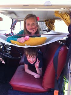 two children sitting in the back of a car