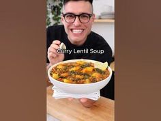 a man is holding a bowl of soup in his hand with the caption curry lentil soup