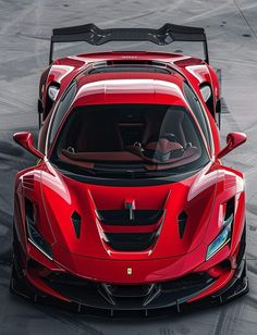 a red sports car is shown from above on a track with its hood up and the front end open