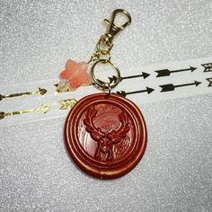 a keychain with a deer head on it and arrows in the back ground