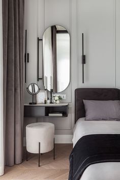 a bedroom with a bed, mirror and stool