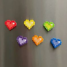 four different colored lego hearts on a metal surface