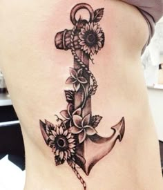 a woman's stomach with an anchor and flowers on it