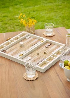 an outdoor game set up on a wooden table with yellow flowers in the vases