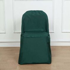 a green chair sitting on top of a hard wood floor next to a white wall