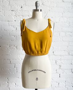 a mannequin wearing a yellow crop top